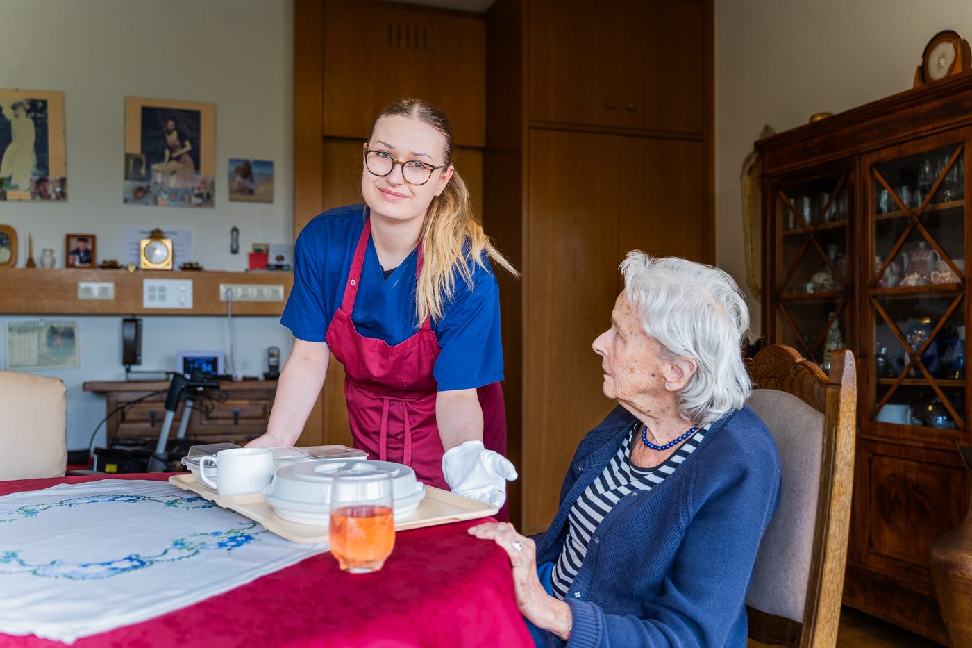 Eine Mitarbeiterin bringt das Mittagessen in die Wohnung